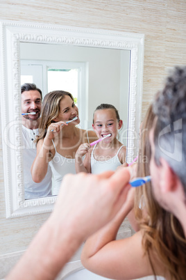 Parents and daughter brushing their teeth in the bathroom