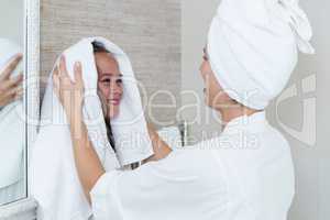 Mother drying her daughters hair with a towel