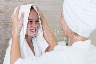Mother drying her daughters hair with a towel