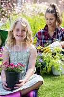 Portrait of girl sitting in garden with flower pot