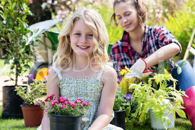 Portrait of girl sitting in garden with flower pot