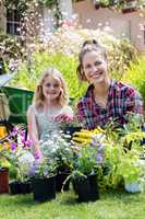Portrait of mother and daughter gardening together in garden