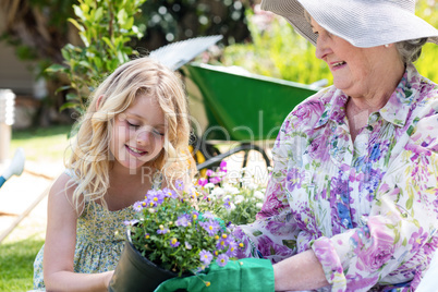 Grandmother and granddaughter holding a flower pot