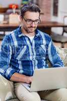 Man sitting on sofa and using a laptop
