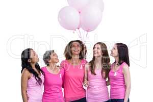 Smiling women in pink outfits posing with balloons for breast ca