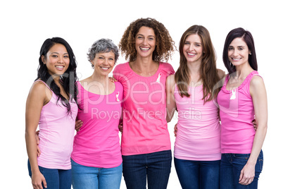 Smiling women in pink outfits posing for breast cancer awareness