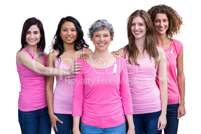 Smiling women in pink outfits posing for breast cancer awareness