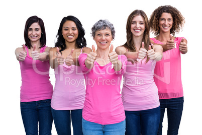 Smiling women in pink outfits showing thumbs up for breast cance