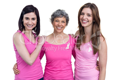 Smiling women in pink outfits posing for breast cancer awareness