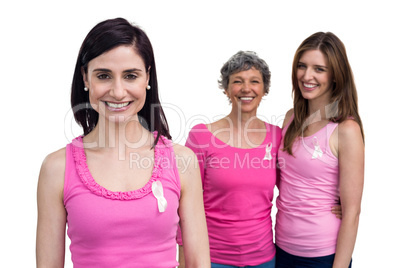 Smiling women in pink outfits posing for breast cancer awareness