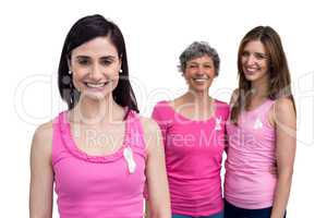 Smiling women in pink outfits posing for breast cancer awareness