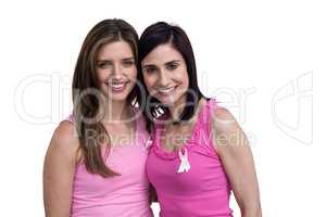 Smiling women in pink outfits posing for breast cancer awareness