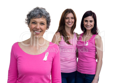 Smiling women in pink outfits posing for breast cancer awareness