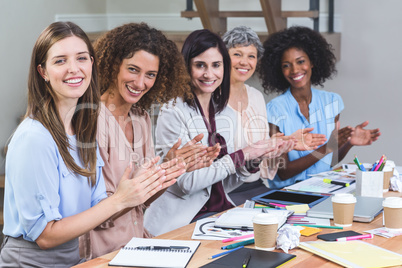 Group of interior designers applauding in office