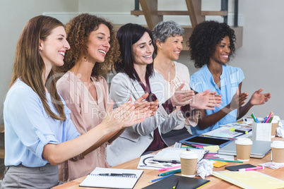 Group of interior designers applauding in office