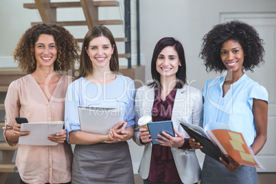 Portrait of female business colleagues standing together with fi