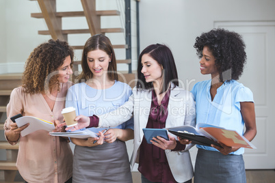 Female business colleagues standing together with file and digit