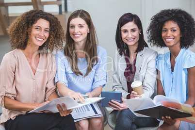 Portrait of female business colleagues sitting together with doc