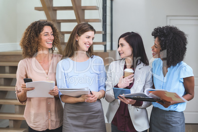 Female business colleagues standing together with file and digit