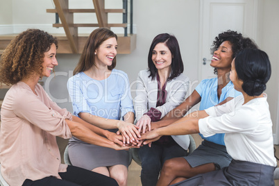 Female business colleagues putting their hands together