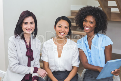 Female business colleagues discussing on digital tablet