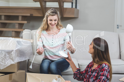 Friends unpacking carton boxes