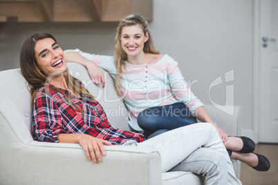 Portrait of two beautiful women sitting on sofa