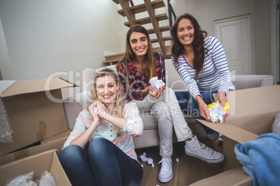 Friends holding packing peanuts in their new house