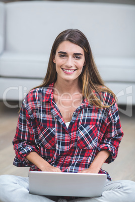 Beautiful woman using a laptop in living room