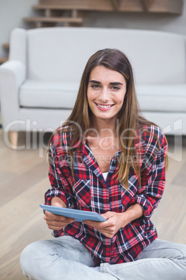 Beautiful woman using digital tablet in living room