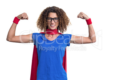 Portrait of smiling woman in superhero costume while flexing mus