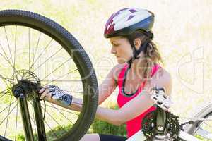 Woman fixing her bike