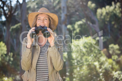 Smiling woman using binoculars