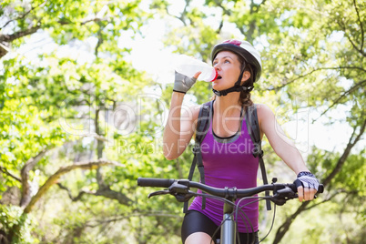 Woman drinking water while cycling
