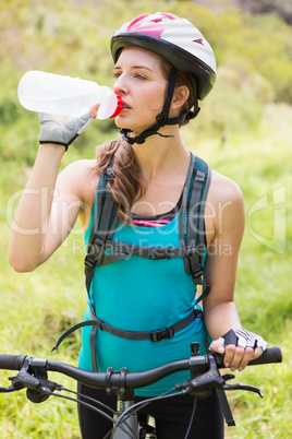 Woman drinking water and wearing helmet