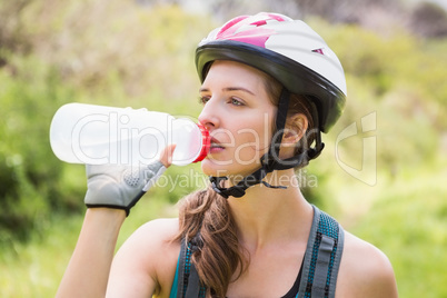 Woman drinking water and wearing helmet