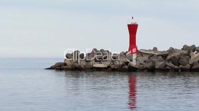 Mole at harbor with red navigational light