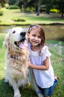 Smiling girl with her pet dog in the park