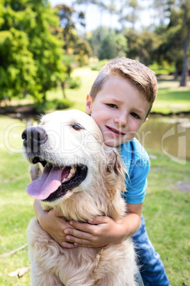 Smiling boy with his pet dog in the park