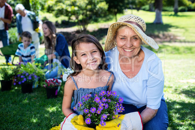 Grandmother and granddaughter holding a flower pot while gardeni