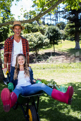 Happy couple playing with a wheelbarrow