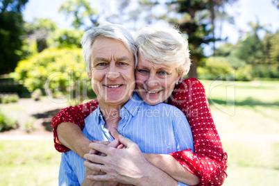 Happy senior couple embracing in park