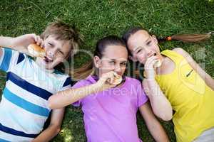 Portrait of children eating bun