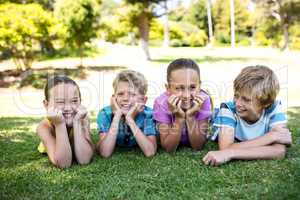 Happy children lying on grass