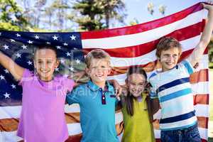 Children holding american flag in park