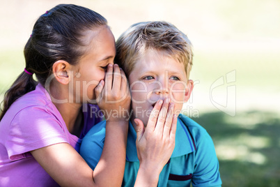 Girl whispering in her brothers ear