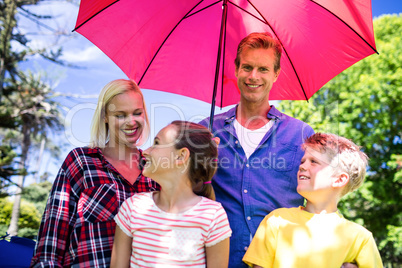 Family standing under umbrella