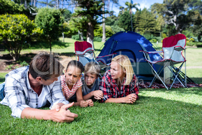 Family talking to each other while lying on grass