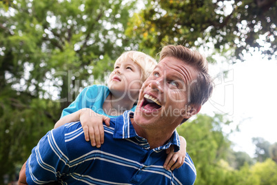 Happy man giving piggyback to his son