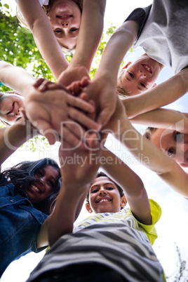 Portrait of happy children putting their hands together